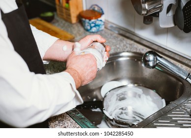 Man Of 59 Year Old Eat Banana In The Kitchen Of His House.