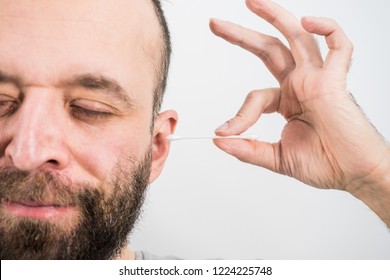 Man About To Clean His Ears Using Q-tip Cotton Swab. Hygiene Essentials Concept. Removing Wax From Ear.