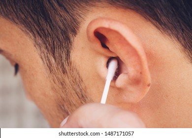 Man About To Clean His Ears Using Q-tip Cotton Swab. Hygiene Essentials Concept. Removing Wax From Ear.