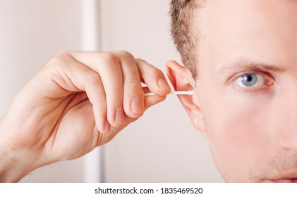 Man About To Clean His Ears Using Q-tip Cotton Swab. Hygiene Essentials Concept. Removing Wax From Ear.
