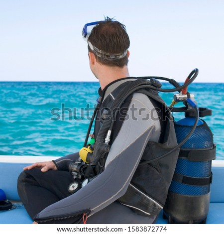 Similar – Foto Bild Glücklicher Mann, der Tauchkleidung und -ausrüstung trägt und lächelt, während er am Strand aus dem Wasser steigt.