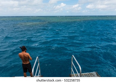 A Man About To Jump In The Water Of The Great Barrier Reef In Queensland, Australia To Snorkel