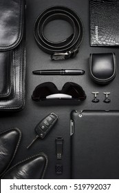 Man accessories in business style, briefcase, gadgets, shoes, clothes and other luxury businessman attributes on leather black background, fashion industry, top view 