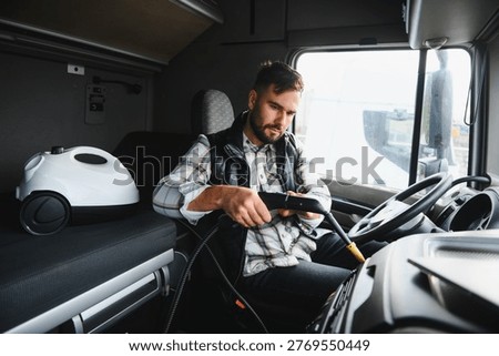 Man actively cleaning the inside of a semi truck cabin with a handheld steam cleaner, ensuring vehicle hygiene and comfort