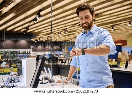 A man is actively exploring a diverse range of smartwatches displayed in a vibrant and exciting electronics store, showcasing the latest cuttingedge technology and current shopping trends in retail