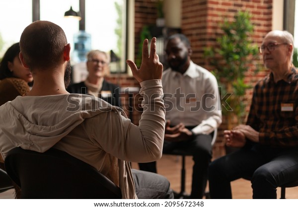 Man\
with addiction sharing health problems with group at aa meeting,\
talking to therapist. Alcoholic people having conversation about\
depression and rehabilitation at therapy\
session.