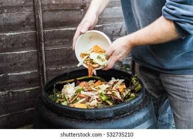 Man adding to compost bin outdoors
