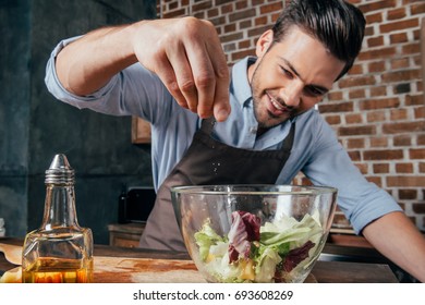 Man Adding Salt Into Fresh Salad