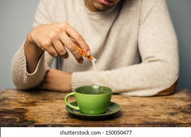 Man Adding Sugar To His Coffee Or Tea