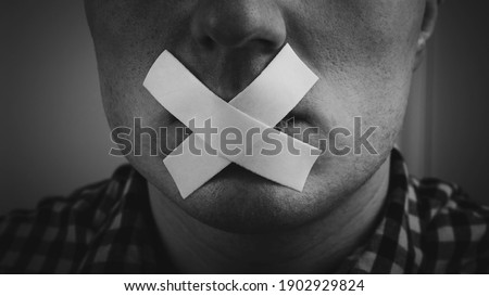 A man with an adhesive plaster sealed his mouth, a man with a closed mouth with adhesive tape, a man cannot open his mouth. Closed mouth