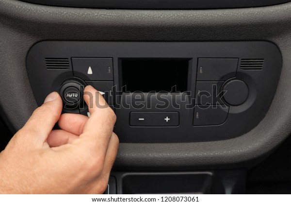 Man adjusting\
air conditioner in car,\
closeup