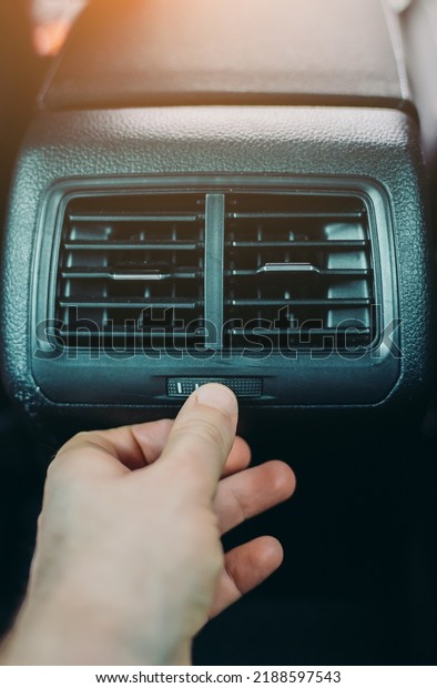 Man adjusting\
air conditioner inside the\
car.