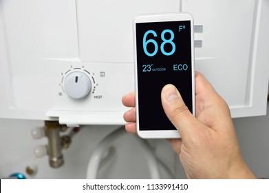 Man Adjusting Burner Temperature With A Phone.