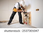 Man adjusting the heating system in a new apartment. Plumber adjusting heat on the central system valves. Service man adjusting house heating system. Underfloor heating system. Man checking pipe