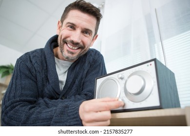 Man Adjusting Volume On His Home Sound System