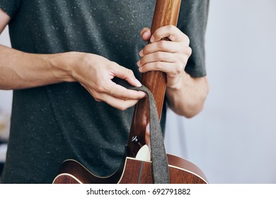 Man Adjusts Guitar Strap                               