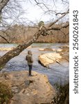 A man is adoring beautiful view along Hewlett Lodge Trail, Chattahoochee River in winter season. The water is calm with emerald green color, great for river-view or doing exercise, jogging around. 