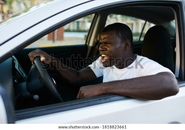 A man
of African appearance driving a road trip
car