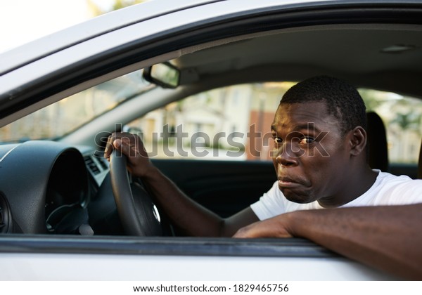 Man of\
African appearance driving a road trip\
car