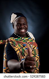 Man african in national cloth pose and laugh on gray background