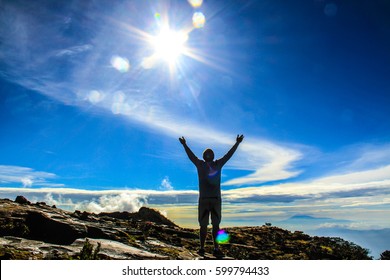 Man After Hiking To The Top Of Mountain Feeling Grateful And Looking To The Sky.