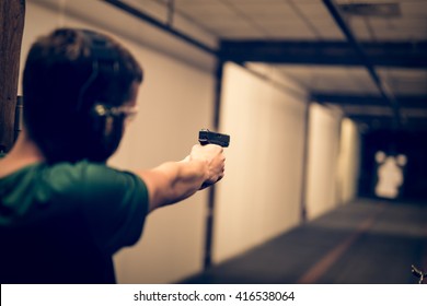 Man Aiming Pistol At Target In Indoor Firing Range Or Shooting Range