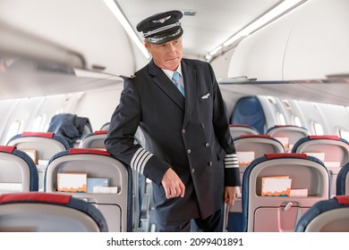 Man Airline Captain Standing In Passenger Airplane Cabin