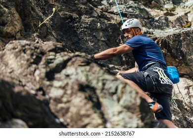 Man With All The Equipment, Climbing On The Rock, Wearing A Hamlet.