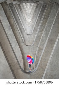 man amd son with his colourful umbrella on abstract pattern background of multiple concrete poles by using telephoto lens