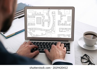 Man analyzing cadastral map on laptop at table, closeup  - Shutterstock ID 2029420412