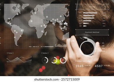 Man analyzing digital data on a transparent screen. World map, graphs, and statistics visible. Focus on data, technology, and analysis. Global statistics and analytics. Man in headphones.