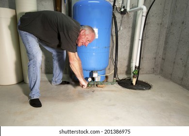 Man With Angry, Red Face Bent Over Well Pump With A Wrench