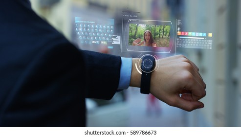 A man answers the wife who smiles and waves from the phone that appears in hologram clock futuristic and technological. Concept: network, communication,family, technology, augmented reality and future