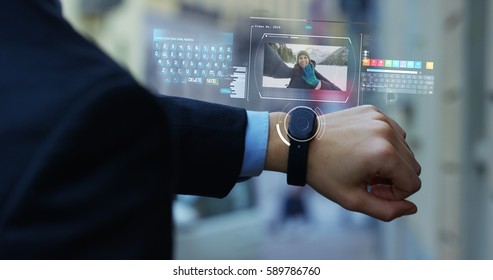 A man answers the wife who smiles and waves from the phone that appears in hologram clock futuristic and technological. Concept: network, communication,family, technology, augmented reality and future
