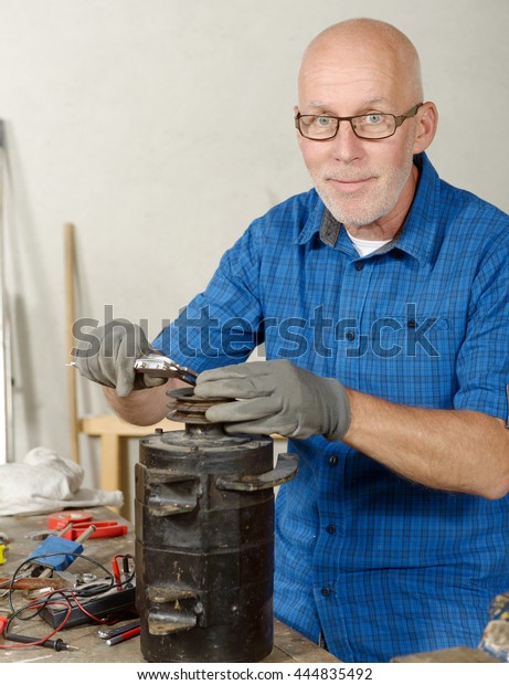a man with antique\
generator for the car