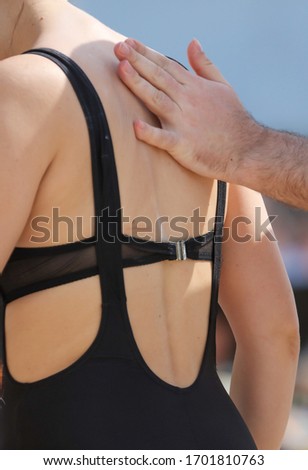 A man applies sunblock to the girl’s back. Holiday at the resort