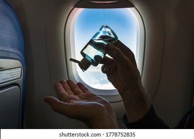 Man applying hand sanitizer gel in airplane. Travelling during corona virus epidemic. Anti-bacterial hand disinfectant in aircraft. - Shutterstock ID 1778752835