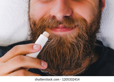 Man Applying Lip Balm In Stick On His Lips. Taking Care Of Skin Concept.