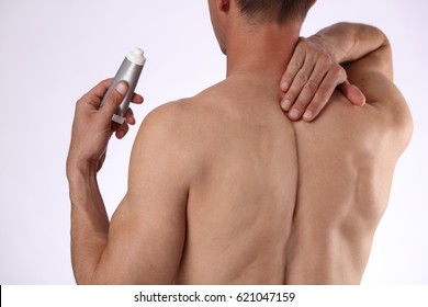 Man Applying Pain Relieving Cream, Gel. Sport Injury, Man With Back, Neck Pain. Pain Relief And Health Care Concept.