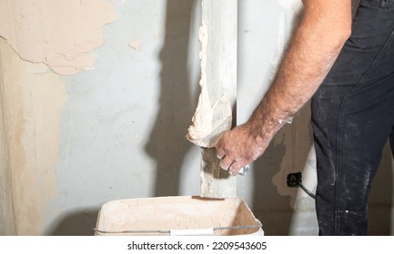 Man Is Applying Putty On A Wall. Renovating House 