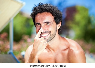 Man Applying Sun Screen On His Nose 