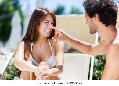 Man Applying Tan Screen On His Girlfriend's Nose