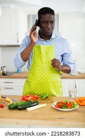 Man In Apron Talking On Phone Making