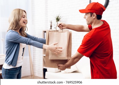 A man of Arab nationality works in delivery. The girl received the parcel delivery to the house. A man in red clothes brought a package to a young woman. - Powered by Shutterstock