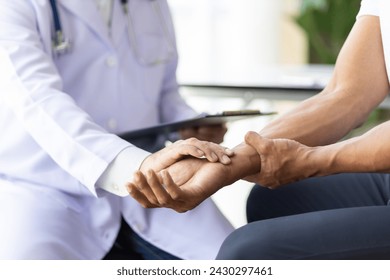 Man with arm pain, wrist pain and shoulder pain is seeing a doctor for diagnosis in an examination room at a hospital. - Powered by Shutterstock