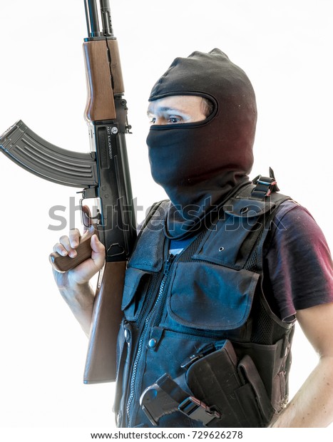 man armed with balaclava and bulletproof\
vest, gun and shotgun,\
kalashnikov