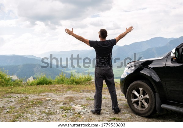 Man arms outstretched by the mountain at sunrise\
enjoying freedom and life, people travel wellbeing concept.\
Traveling by car concept\
image.