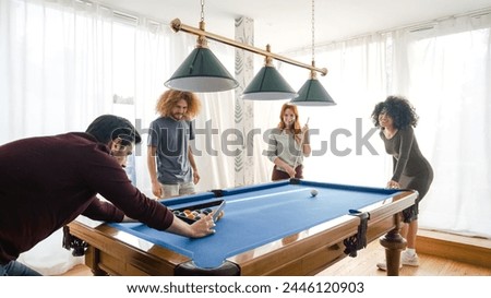 Man arranging balls for multiethnic friends playing pool in game room