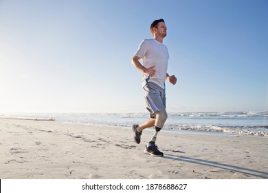 Man With Artificial Leg Running Along The Beach