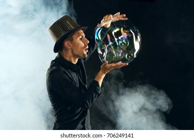 Man Artist Blowing Many Soap Bubble. Soap Bubble Show In Black Studio.